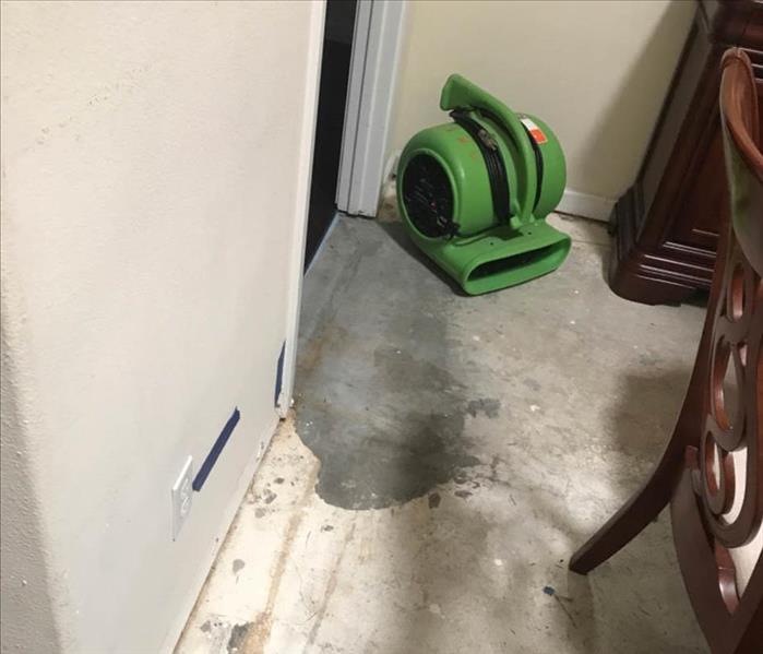 Green air mover on cement flooring.