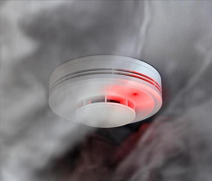 smoke circulating around an alarm attached to the ceiling